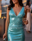 NAAMA ATHENS turquoise sequin mini dress with V-neck, lace trim, and bow detail worn by a woman at an evening party.